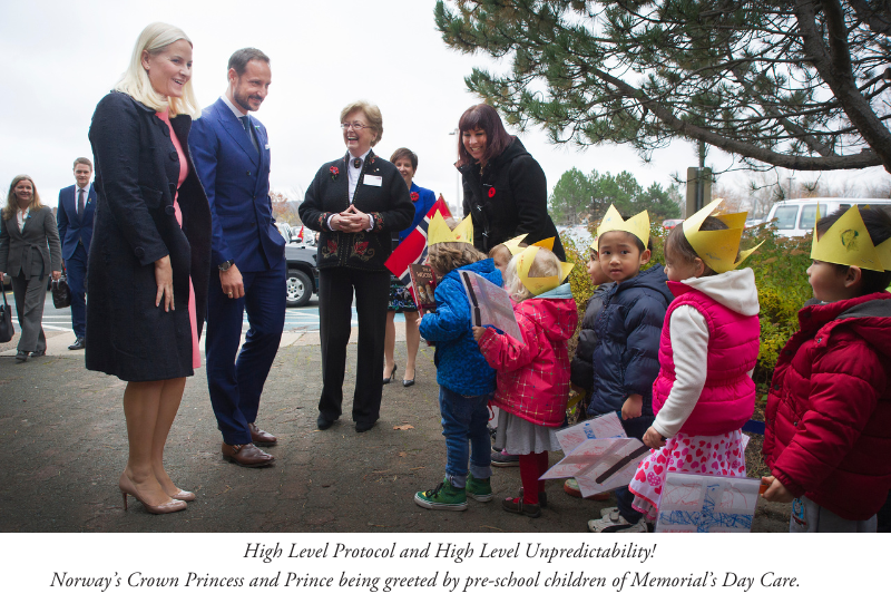 Adults and children outdoors.  Norway’s Crown Princess and Prince being greeted by pre-school children of Memorial’s Day Care.